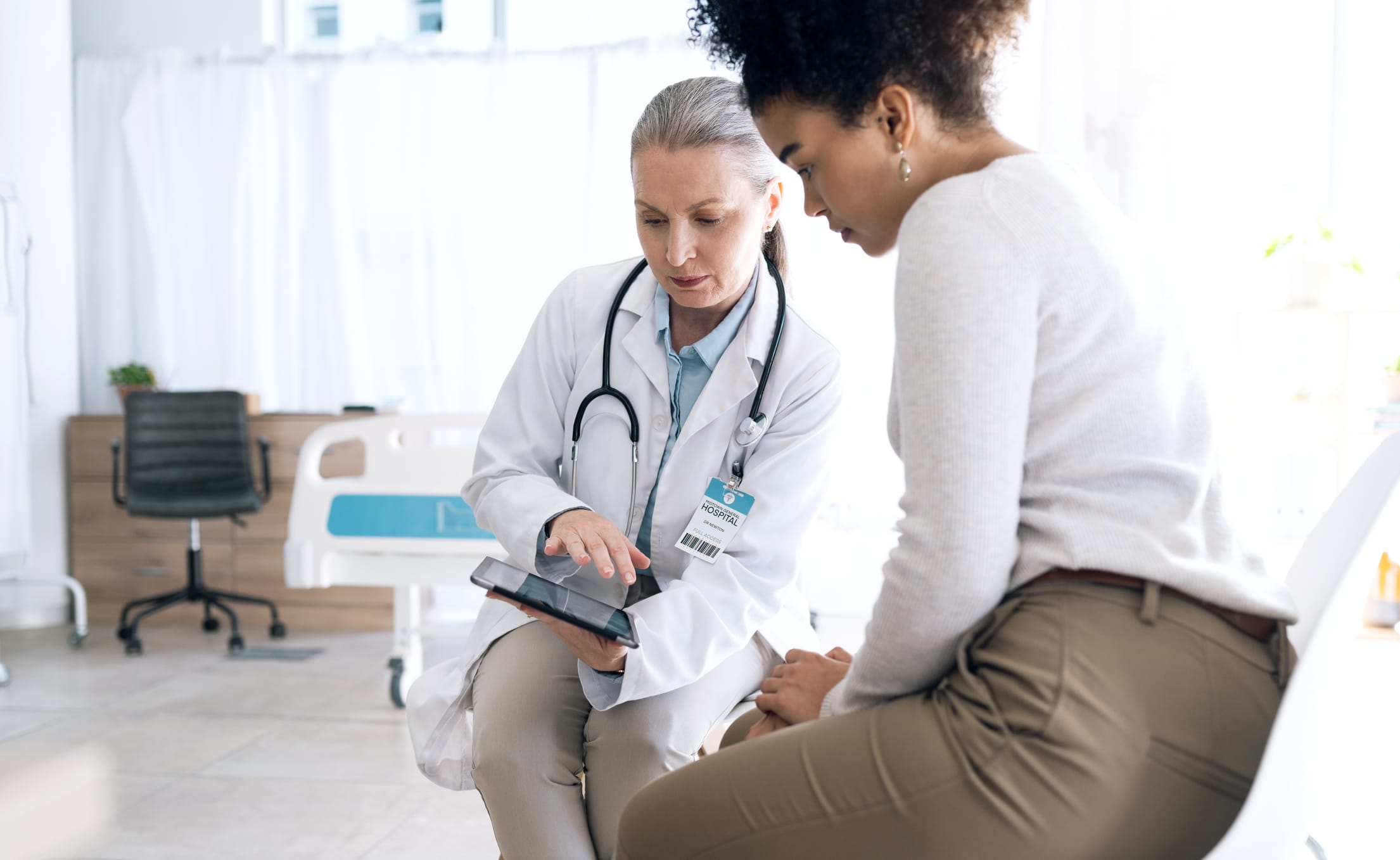woman looking at a tablet with her doctor