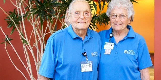 elderly volunteers in matching blue shirts